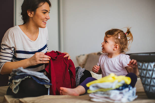 Mother and her daughter folding laundry together